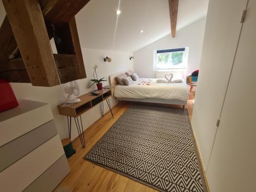 een kleine slaapkamer met een bed en een tapijt bij Jade room in Saint-Romain-Lachalm