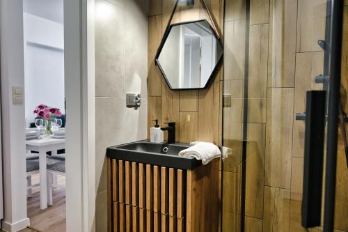 ein Bad mit einem Waschbecken und einem Spiegel in der Unterkunft Apartament Lider 41 by Housine in Zator