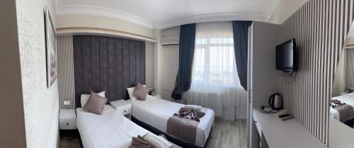 イスタンブールにあるDivas Silverのベッド2台とテレビが備わるホテルルームです。