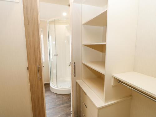 a bathroom with a walk in shower and a toilet at 36 Raven's Rest in Carlisle