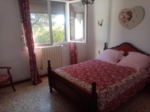 um quarto com uma cama e uma janela em Les mûriers - Etage complet d'une grande maison em Argeliers