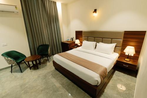 a hotel room with a bed and a desk and chairs at Grand Heritage Hotel & Resort in Ludhiana