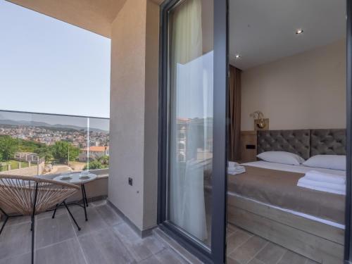 - une chambre avec un grand lit et un balcon dans l'établissement Hotel Diman, à Dobra Voda