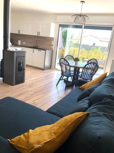un salon avec un canapé bleu et une table dans l'établissement Entre plage et détente aux Conches, Maison avec terrasse et jardin privé, à Longeville-sur-Mer