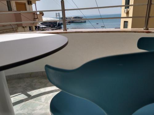 een balkon met een tafel en een blauwe stoel bij Durazzo Vollga 1 in Durrës