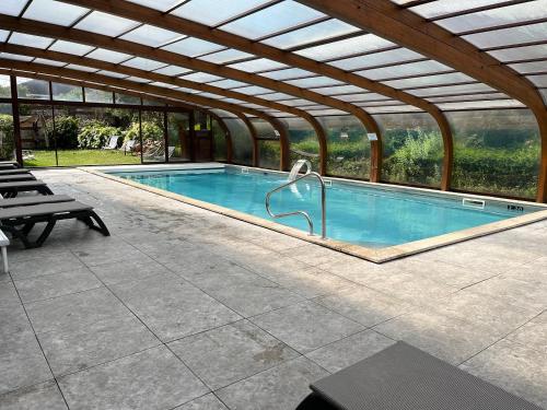 a swimming pool in a building with a roof at Tulip Inn Honfleur Residence & Spa in Honfleur