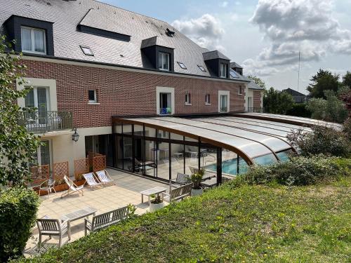 a building with a patio and a swimming pool at Tulip Inn Honfleur Residence & Spa in Honfleur