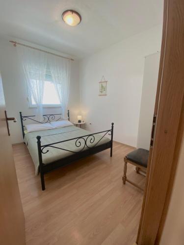 a bedroom with a bed and a window at Apartment Doris in Kaštela