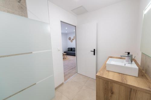 a white bathroom with a sink and a mirror at KASA ZEN - Climatisation - Tout équipé - Stationnement gratuit in Saint-Chamond