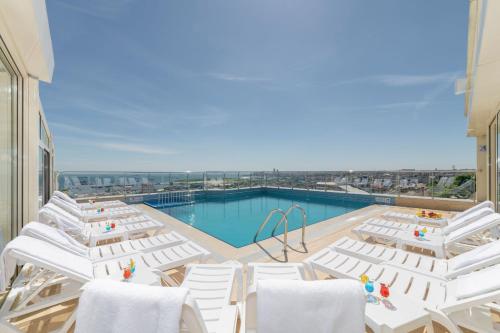 a pool with white chairs and a swimming pool at Piya Sport Hotel in Istanbul