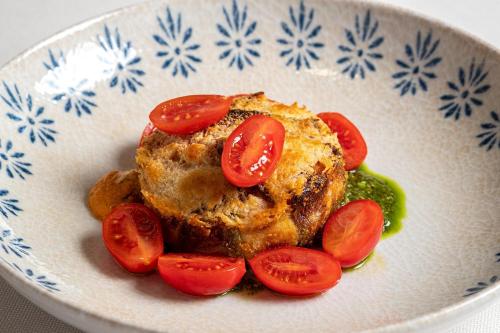 a plate of food with tomatoes and sauce at Hotel Villa Mabapa in Venice-Lido