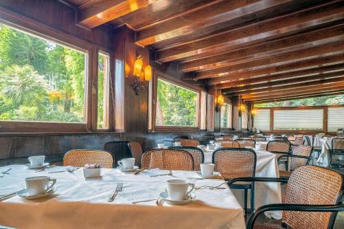 a dining room with tables and chairs and windows at Hotel Villa Mabapa in Venice-Lido