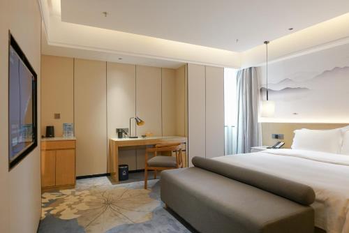 深セン市にあるPaco Hotel Shenzhen Luohu Portのベッドとデスクが備わるホテルルームです。