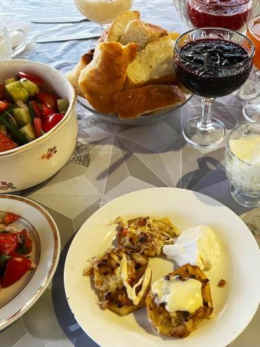 a table with a white plate of food and a bowl of food at Guest House Doktor Eismann in Chychkan