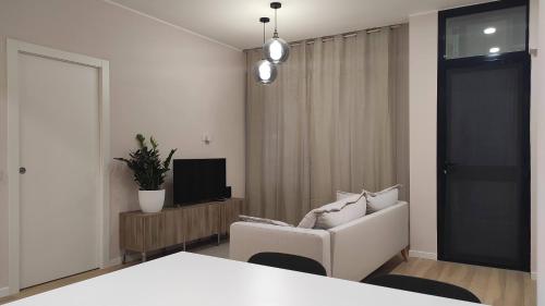 a white room with a white chair and a television at Casa Vacanze Como in Como