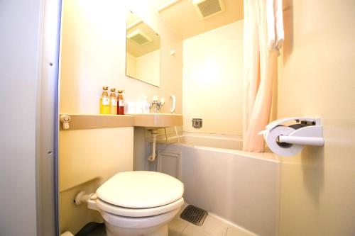 a small bathroom with a toilet and a sink at Heiwadai Hotel Tenjin in Fukuoka