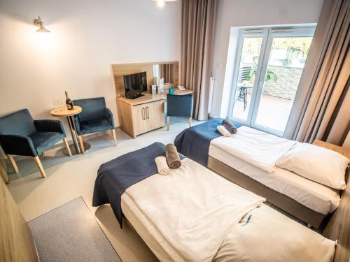 a hotel room with two beds and a television at Sanatorium Muszelka in Kołobrzeg