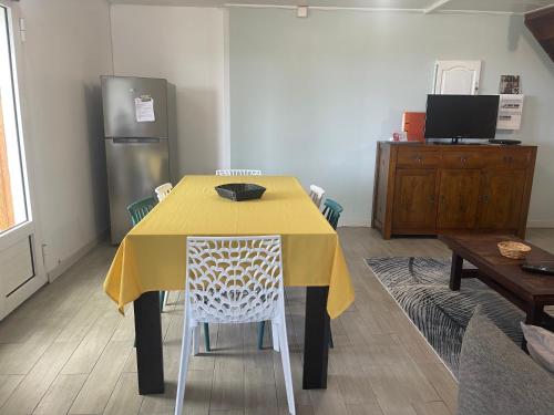 a dining room table with a yellow table cloth on it at ti Kaz Papang in La Plaine des Cafres