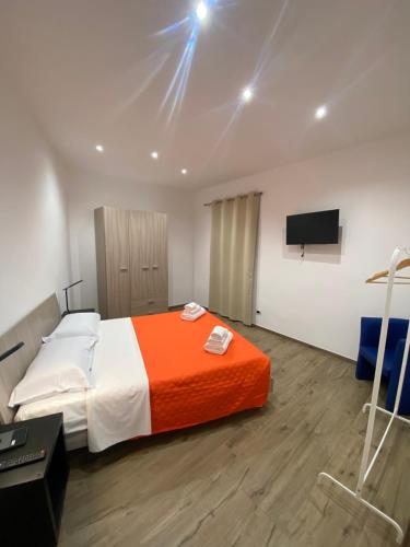 una camera con un letto con una coperta arancione e bianca di B&B Leoncavallo a Grottaglie