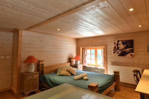 um quarto com uma cama num chalé de madeira em Le Vallorcin, chalet le Sizeray - Mont Blanc em Vallorcine