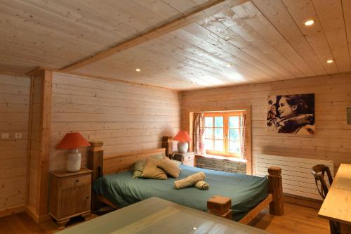 une chambre avec un lit dans une cabane en rondins dans l'établissement Le Vallorcin, chalet le Sizeray - Mont Blanc, à Vallorcine
