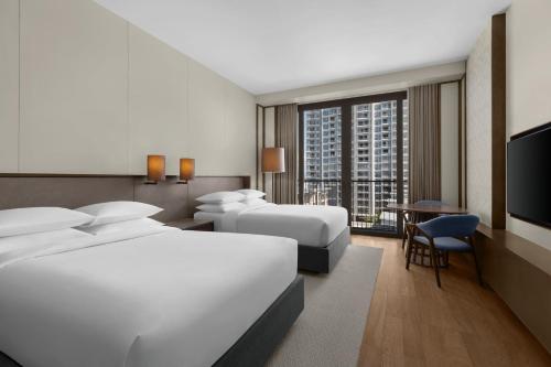 麥克坦的住宿－Sheraton Cebu Mactan Resort，酒店客房设有两张床和电视。
