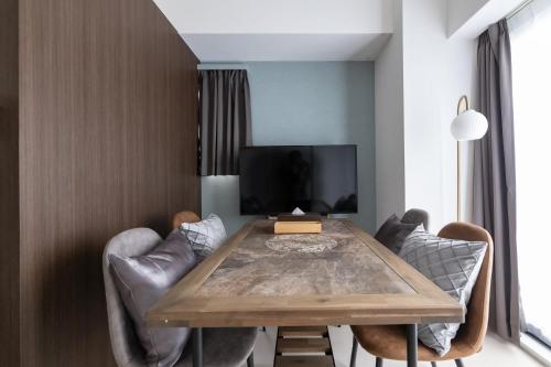 a dining room with a wooden table and chairs at Primavera Namba Minami in Osaka