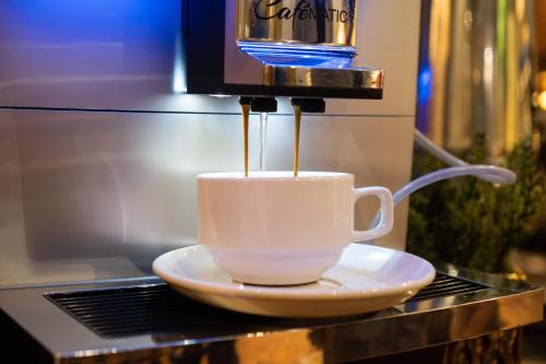 Una taza de café sobre una mesa con una máquina de café. en Grand Swiss-Belhotel Melaka, en Melaka