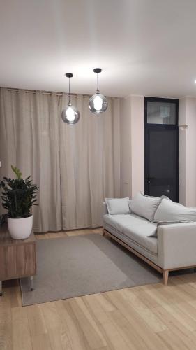 un divano bianco in soggiorno con due luci di Casa Vacanze Como a Como