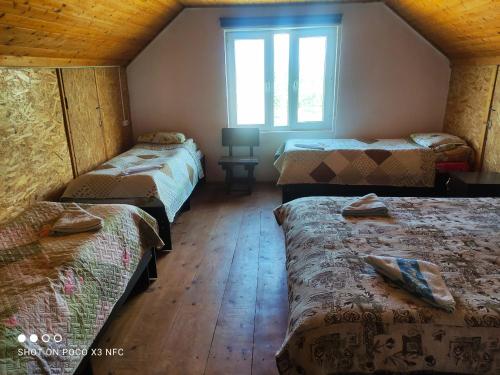 Habitación con 3 camas y ventana en Guest House Doktor Eismann, en Chychkan