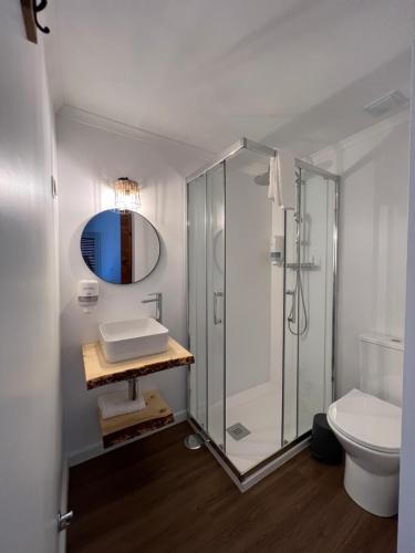 a bathroom with a shower and a sink and a toilet at Fishermans House in Almograve
