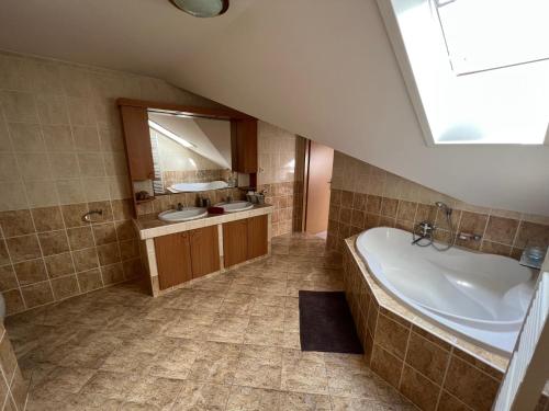 a large bathroom with a tub and a sink at Ubytování u Novotných in Vyšší Brod