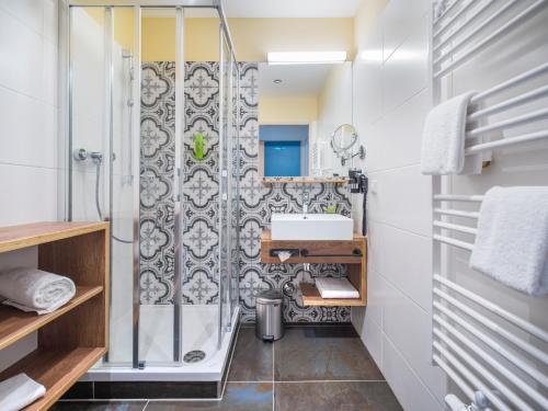 a bathroom with a shower and a sink at JUFA Hotel Salzburg City in Salzburg