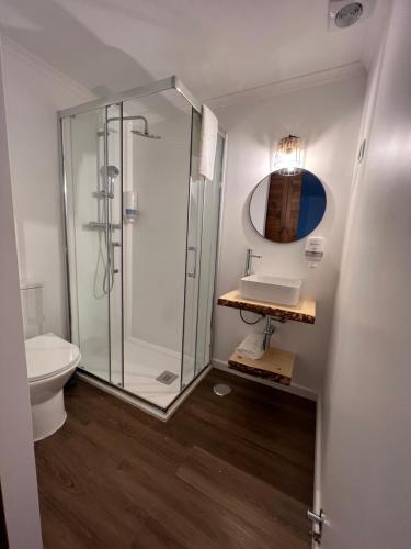 La salle de bains est pourvue d'une douche en verre et d'un lavabo. dans l'établissement Fishermans House, à Almograve