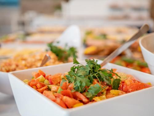 een kom voedsel op een tafel met andere voedingsmiddelen bij Sanatorium Muszelka in Kołobrzeg