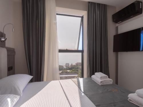 a bedroom with a bed and a large window at Hotel Diman in Dobra Voda