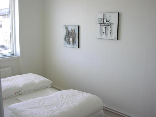 スケーエンにあるPlesners Anneksの壁に3枚の絵が飾られた部屋にベッドが2つある