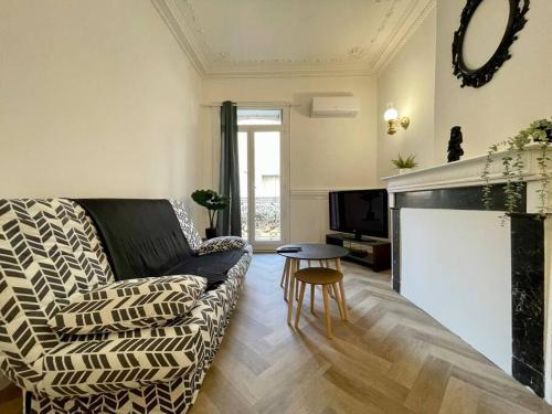 un salon avec un canapé et une cheminée dans l'établissement Le repos du chameau ઼ climatisé, à Béziers