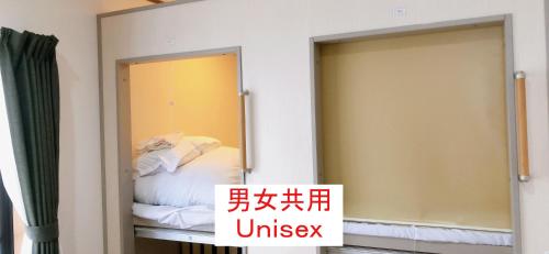 a mirror in a room with a bed at HOSTEL198 in Osaka