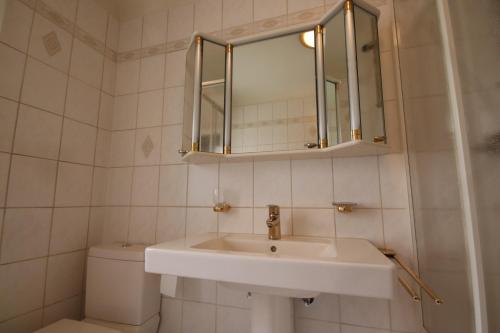 a bathroom with a sink and a toilet and a mirror at Monteurwohnung Saarlouis, Ferienhaus, WLAN, Parkplatz in Saarlouis