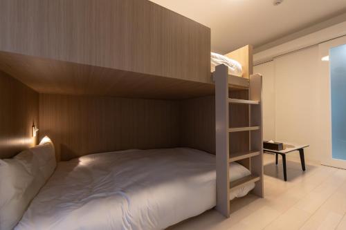 a bedroom with a bunk bed and a desk at Primavera Namba Minami in Osaka