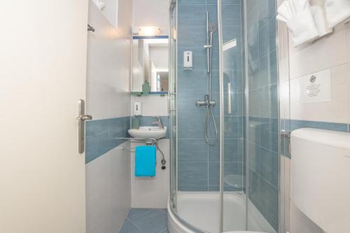 a bathroom with a shower and a toilet and a sink at Pansion Pirat in Petrcane