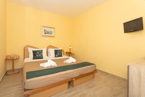 a bedroom with a bed with a tv on the wall at Pansion Pirat in Petrcane