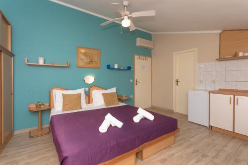 a bedroom with a purple bed with white shoes on it at Pansion Pirat in Petrcane