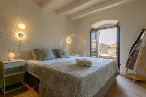 a bedroom with a bed with towels on it at PALS - Maison médiévale tout confort in Pals