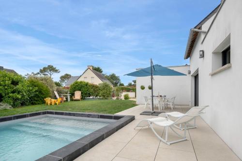 une terrasse avec une piscine, une table et des chaises dans l'établissement Maison pour 6 - Piscine chauffée - 700m plage, à Sarzeau