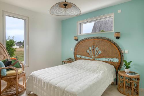 a bedroom with a large bed and two windows at Maison pour 6 - Piscine chauffée - 700m plage in Sarzeau