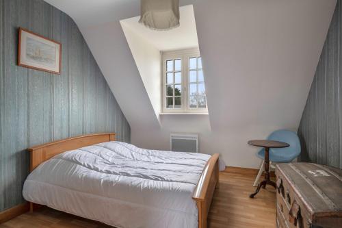 um pequeno quarto com uma cama e uma janela em Echappee familiale pres de la plage a Sarzeau em Sarzeau