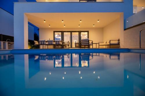 a house with a swimming pool at night at Villa Aria in Klimno