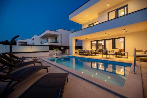 a villa with a swimming pool at night at Villa Aria in Klimno